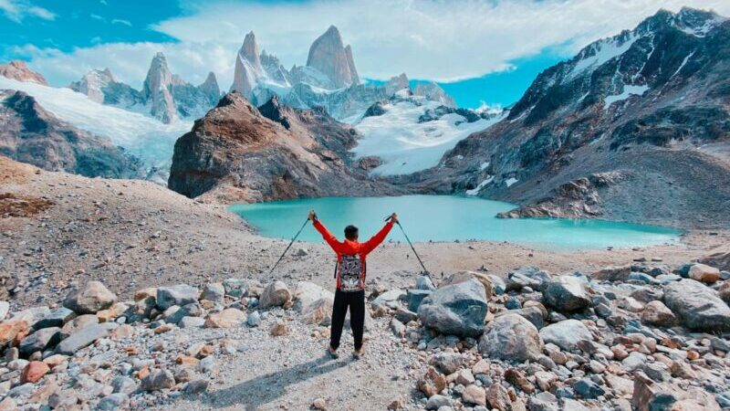 Back View of a Man Standing with His Arms Spread in Laguna de los Tres, Argentina